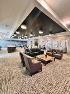 view of a meeting room with an arrangement of chairs and sofas facing each other on a black and cream carpet tile floor