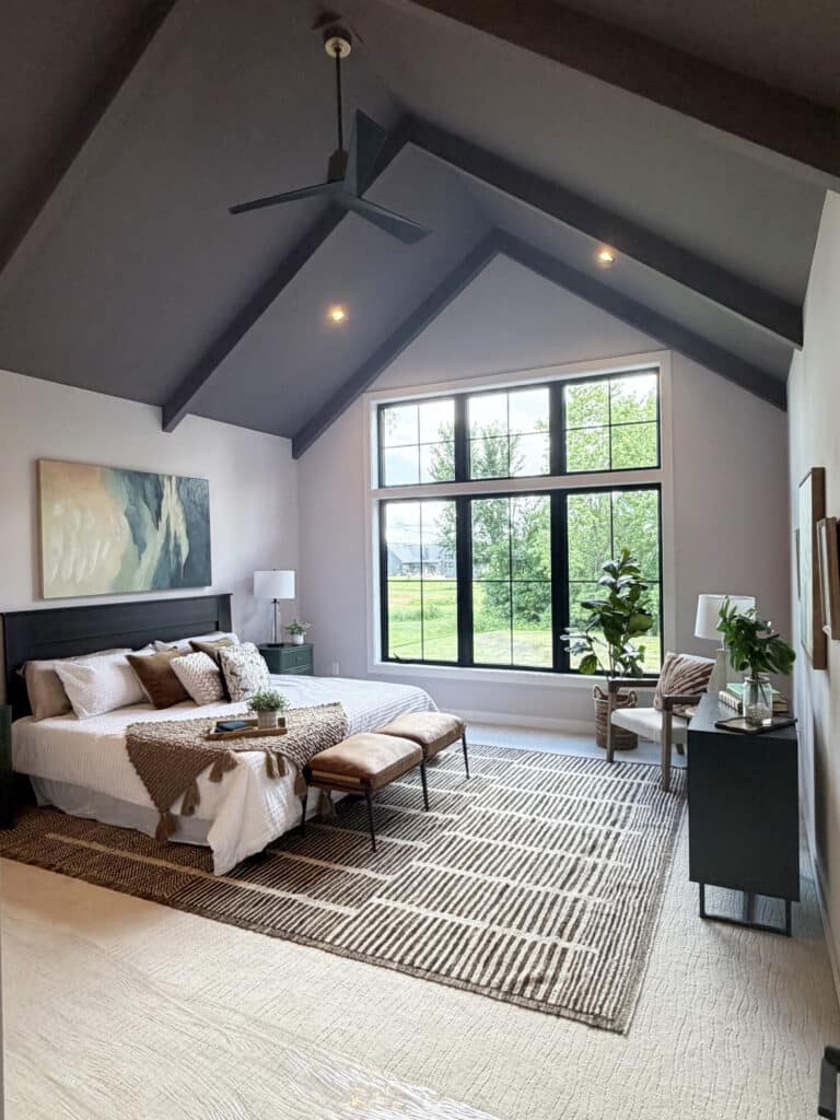 primary bedroom with wall to wall carpet and an area rug on top of it placed under the bed