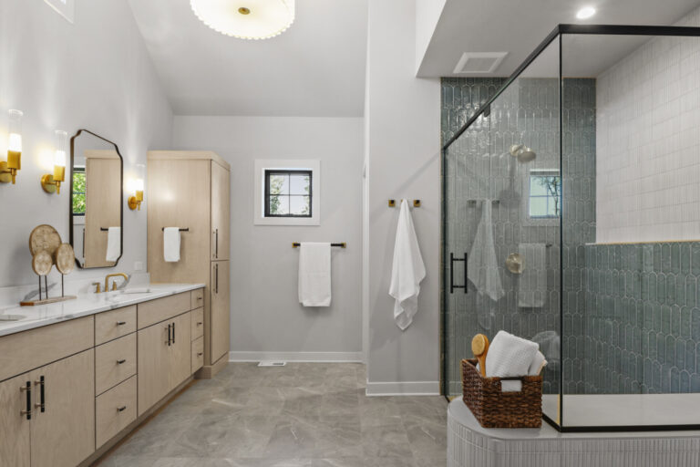 primary bathroom with marble tile floor and green teal zellige shower wall seen through glass enclosure