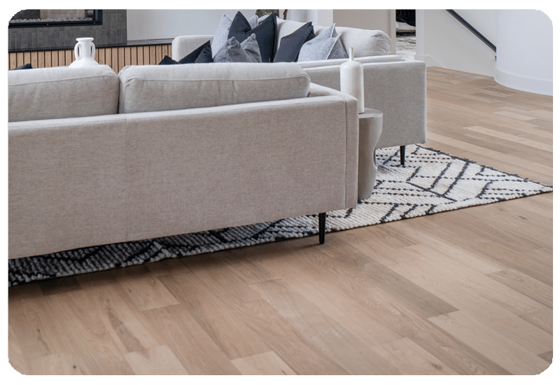 Light natural engineered hardwood flooring in a Madison, Wisconsin living room with layered area rug