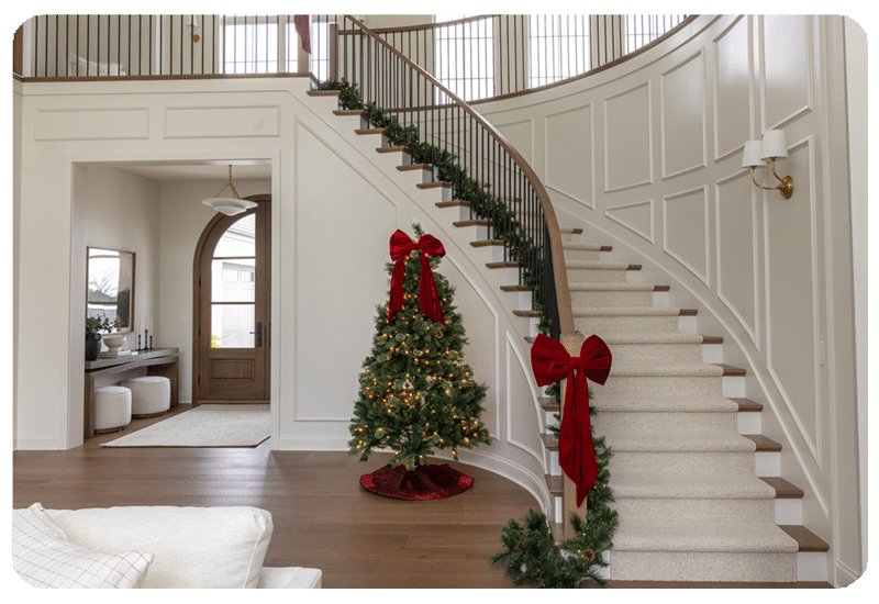view of a spiral staircase with carpet stair runner and christmas tree and garland