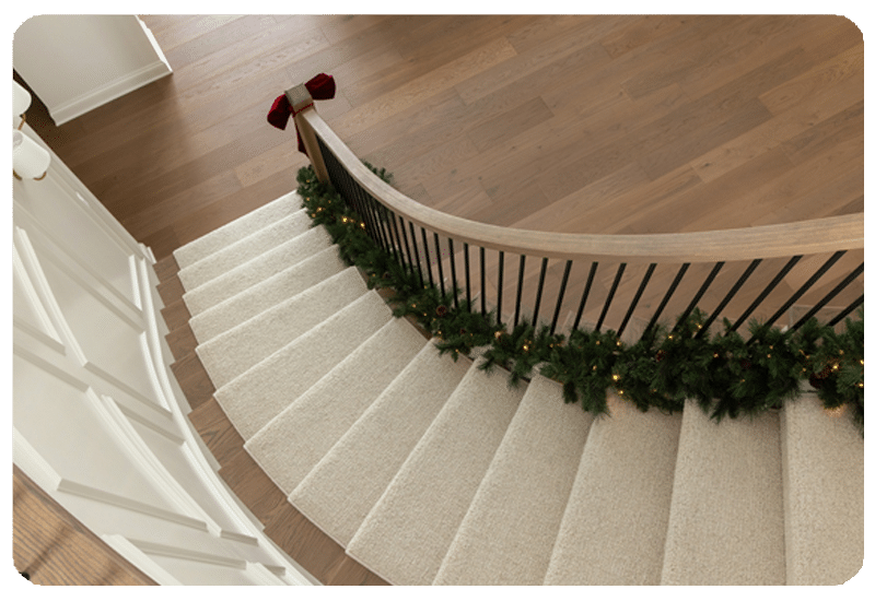 view from above spiral staircase carpet runner with holiday garland