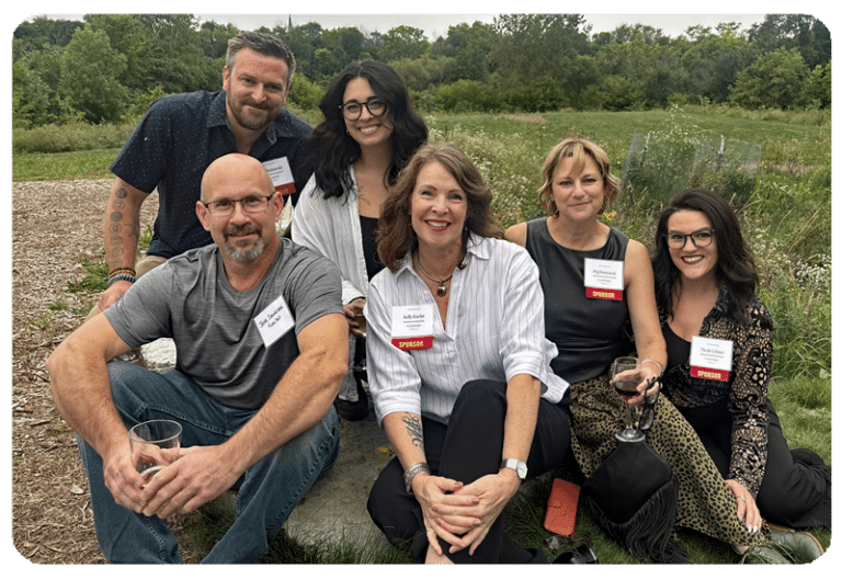 FLOOR360 Milwaukee design team installers and interior designers sitting in a green field