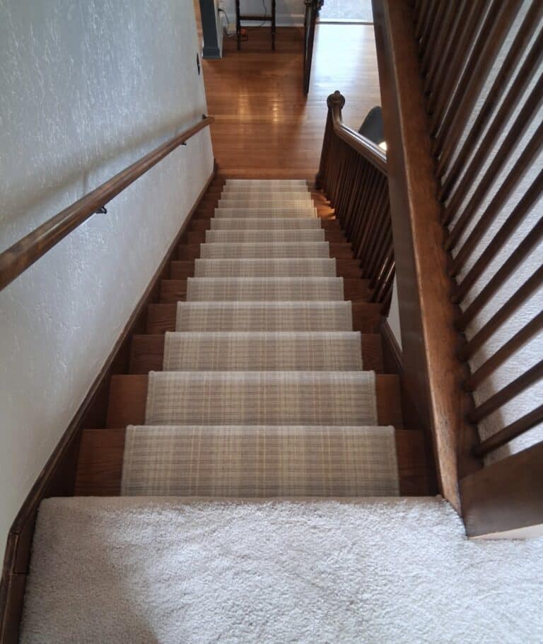 plaid neutral color stair carpet runner on wood staircase and wood railing