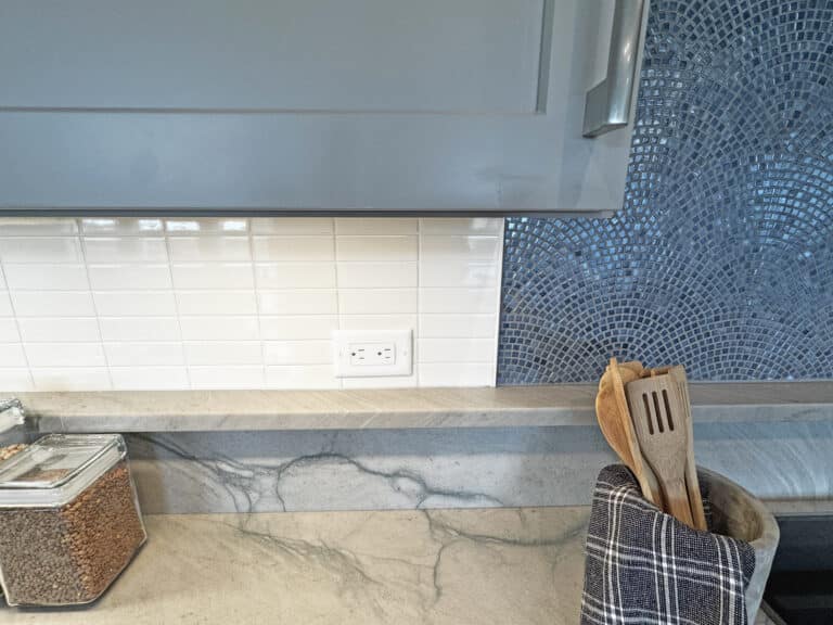 close up of white subway tile backsplash and blue mosaic tile backsplash