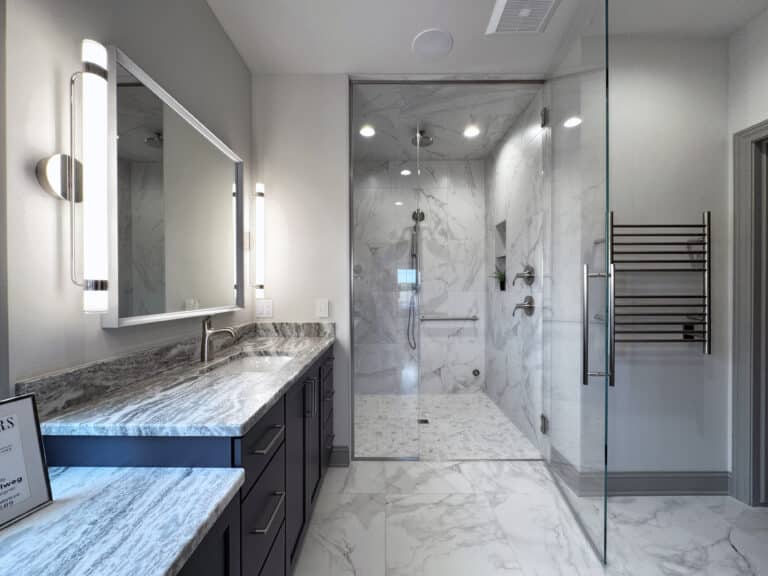 primary bathroom with white marble tile floor glass enclosed shower with white marble tile floor