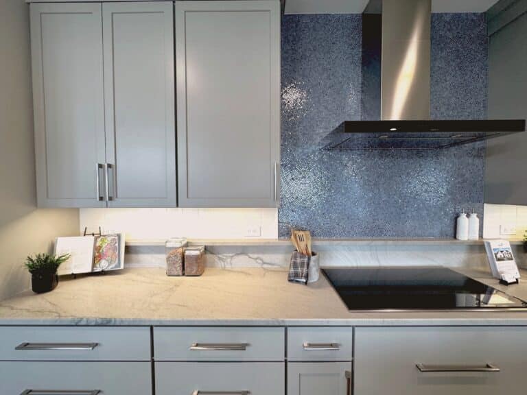 kitchen cabinets with white tile subway style and a blue mosaic above the stove