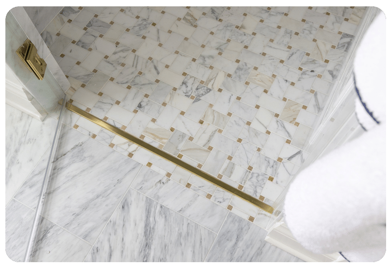 Marble mosaic tile bathroom floor with brass trim in a Madison-area home, a classic choice over radiant floor heating